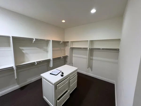 Before: walk-in closet with basic white shelving and a small island, Lake Sherwood