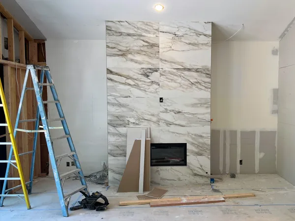 Before: stone fireplace wall under construction with ladders and open framing, Lake Sherwood