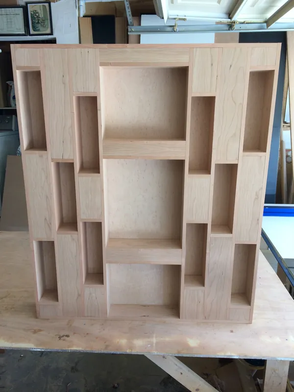 Cherry pop bottle display on the shop bench before finishing, showing the staggered bird’s-eye maple niches