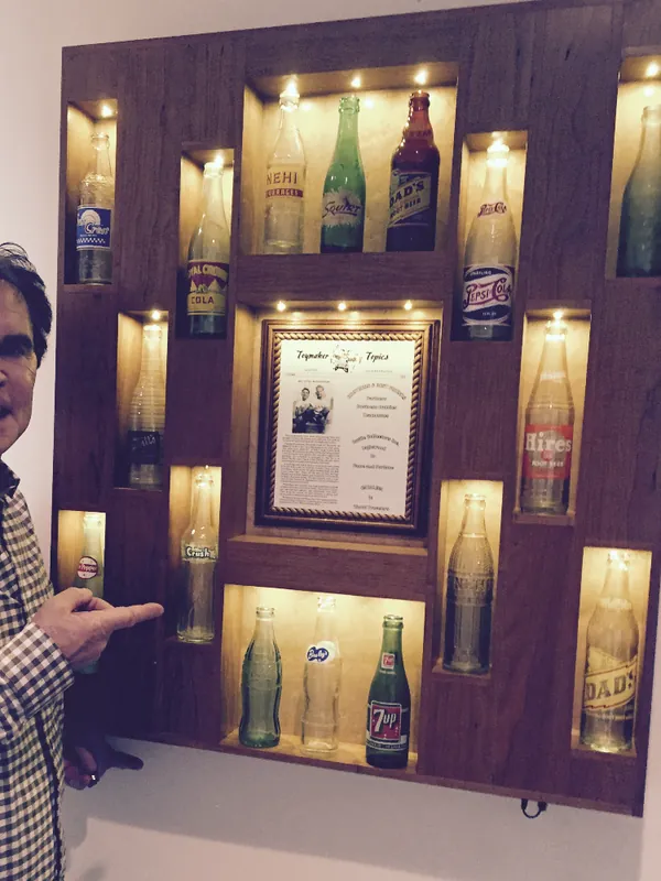 Joe pointing to a bottle in his finished pop bottle display, Agoura Hills