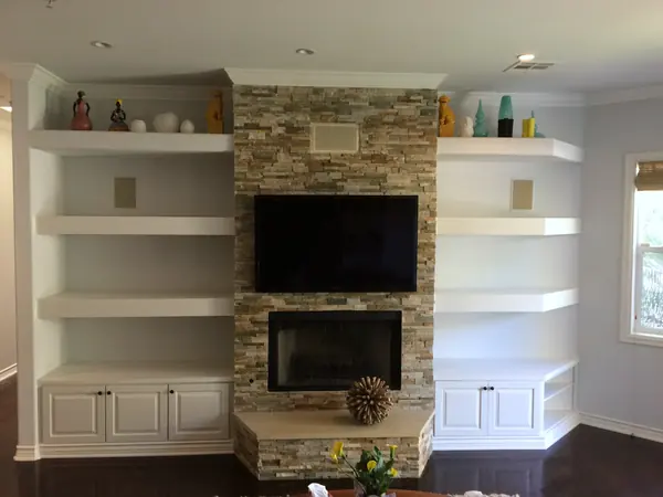 Fireplace wall with white floating shelves and base cabinets on both sides, Woodland Hills