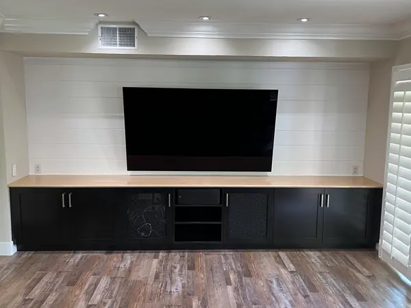 Long black media console with a wood top under a shiplap wall, Moorpark