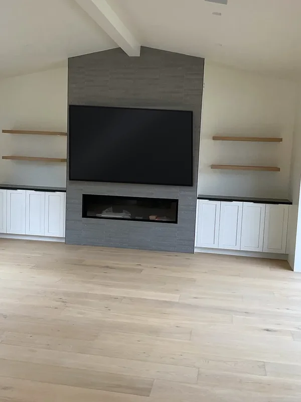 Media wall with a linear fireplace, floating shelves and white base cabinets, Westlake Village