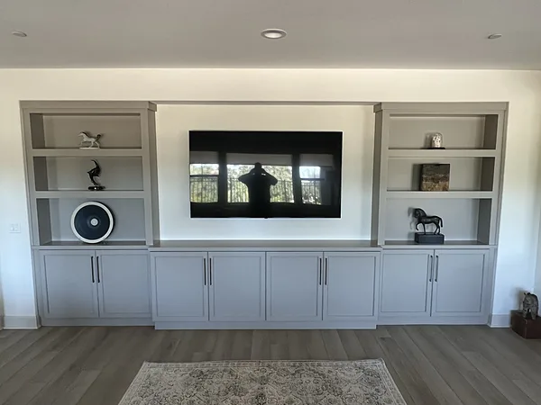 Gray media wall with open shelving towers and base cabinets on both sides of the TV, Camarillo