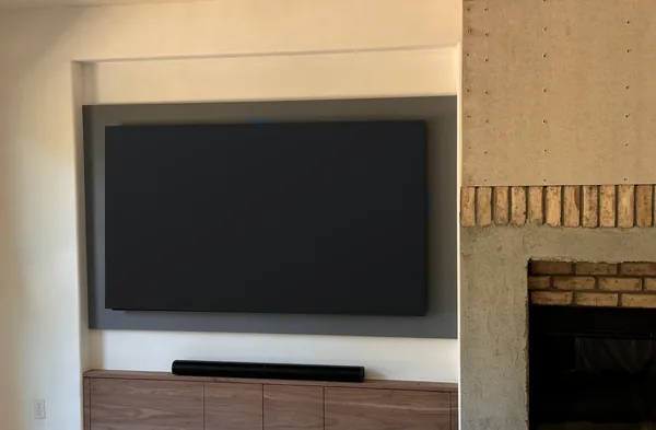 Media wall with a TV niche over a wood console beside a brick fireplace, Westlake Village