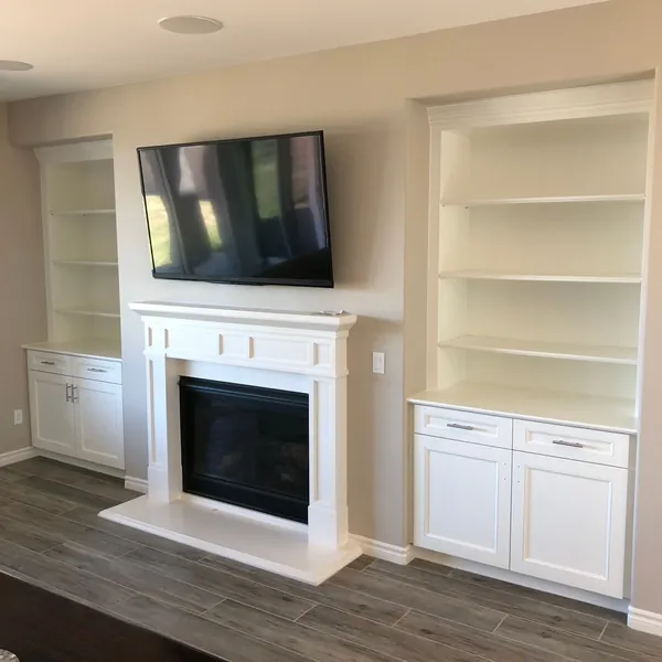 White bookcases over base cabinets on both sides of a white fireplace mantel, Moorpark