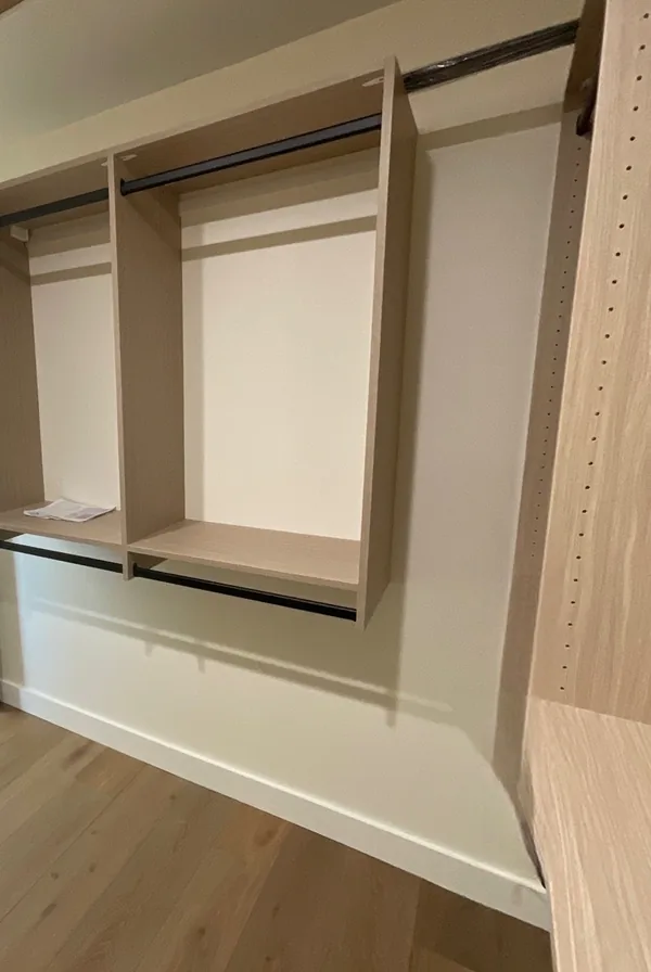 Double-hang section in a walk-in closet with a top shelf