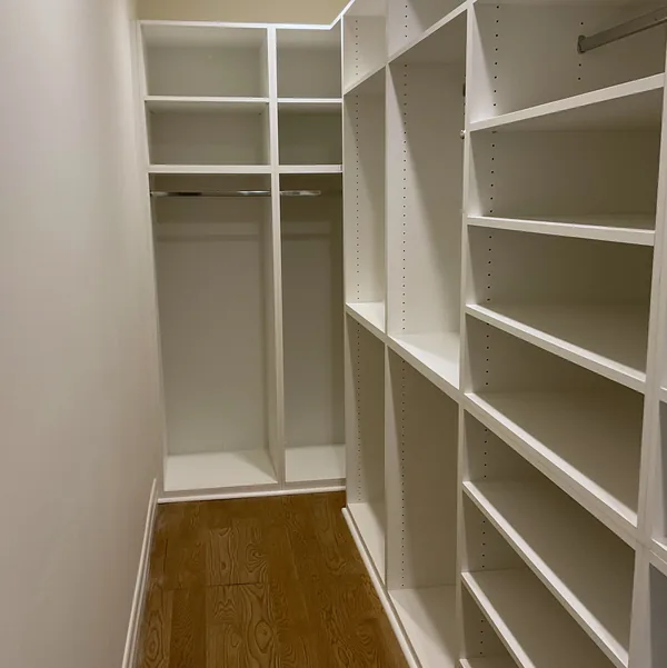 Walk-in closet with white adjustable shelving and long and short hanging
