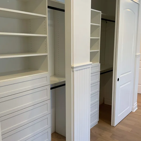 Walk-in closet with double bays of hanging rods and drawers