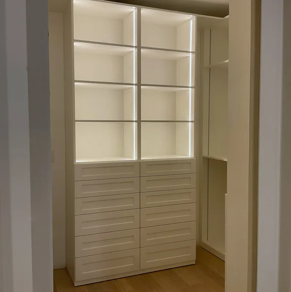 Walk-in closet with twin shelving towers, LED shelf lighting and drawers