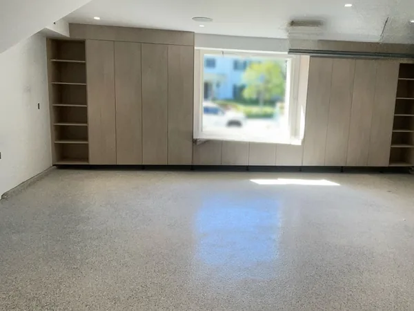 Garage storage wall with full-height oak cabinets, open shelf towers and a bench under the window, Lake Sherwood