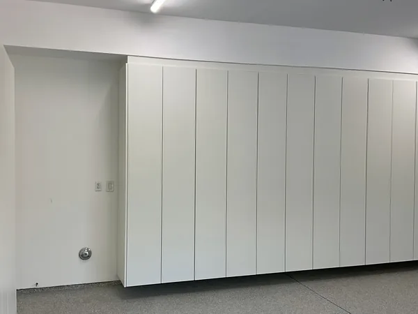 Wall of tall white flat-panel garage cabinets raised off the floor, Hidden Hills