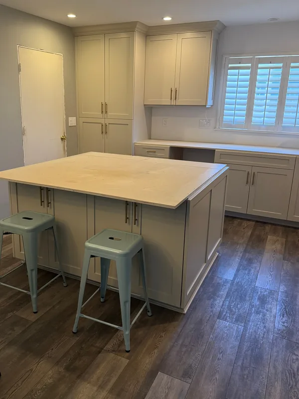 Light kitchen cabinets with a butcher-block island and two stools, Camarillo