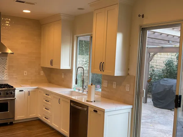 L-shaped white shaker kitchen running toward a patio door in Newbury Park