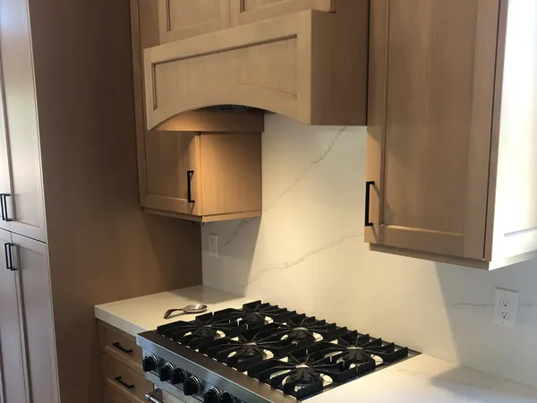 Light oak shaker cabinets with an arched wood hood over a professional range, Santa Rosa Valley