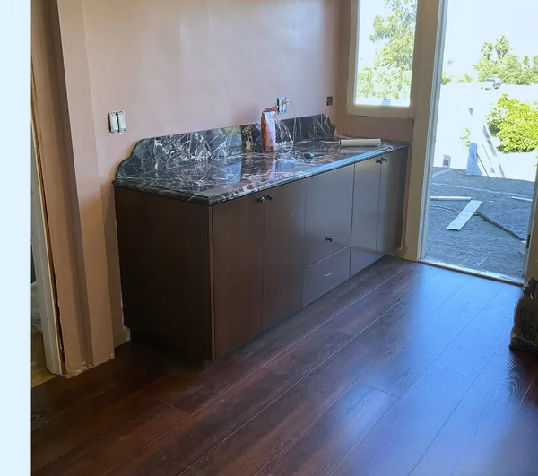 Stained wood base cabinets with a granite top by a patio door, Moorpark