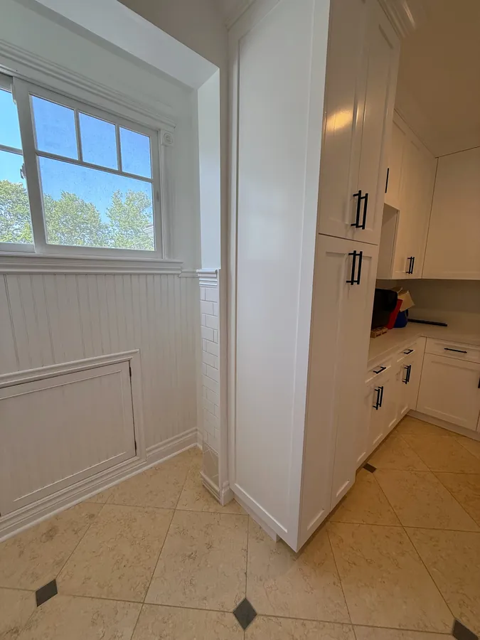 Tall white shaker laundry and mudroom storage cabinets