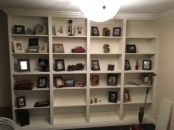 White floor-to-ceiling bookcase wall with display shelves in a Camarillo home