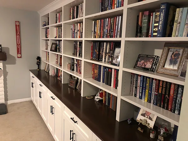 White base cabinets with a dark top and open bookshelves above in a Camarillo home