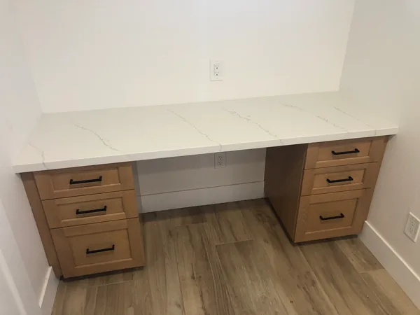 Built-in desk with a white quartz top between two light oak drawer pedestals, Santa Rosa Valley