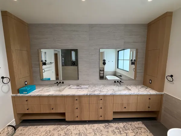 Floating oak double vanity with flanking tall cabinets and a stone top, Thousand Oaks