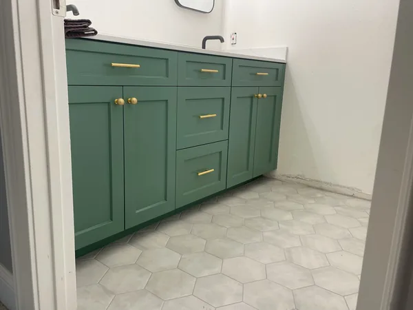 Green shaker vanity with drawers and brass pulls on a hexagon tile floor, Newbury Park