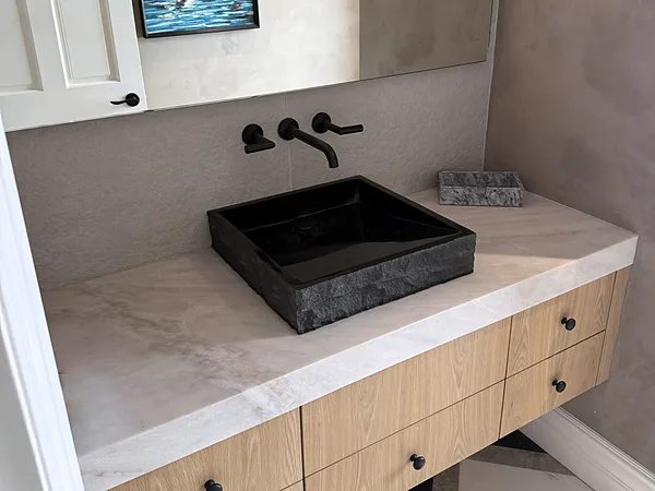 Floating white oak vanity with a black stone vessel sink and wall-mounted faucet in Lake Sherwood, Westlake Village