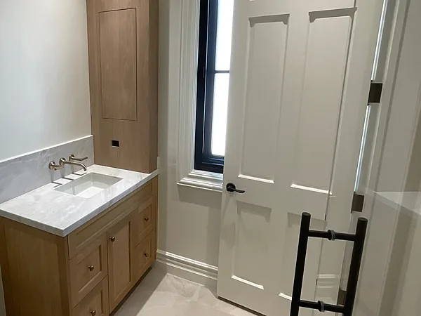 Oak shaker powder room vanity with a marble top and a matching tall linen cabinet in Lake Sherwood, Westlake Village