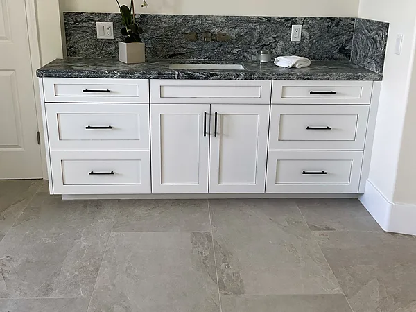 White shaker vanity with drawers, doors and a dark stone top and backsplash in Somis, near Camarillo