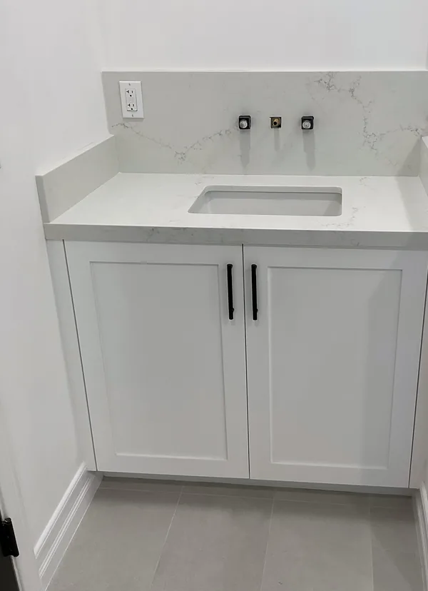 White shaker bathroom vanity with a stone top and black hardware, Hidden Hills