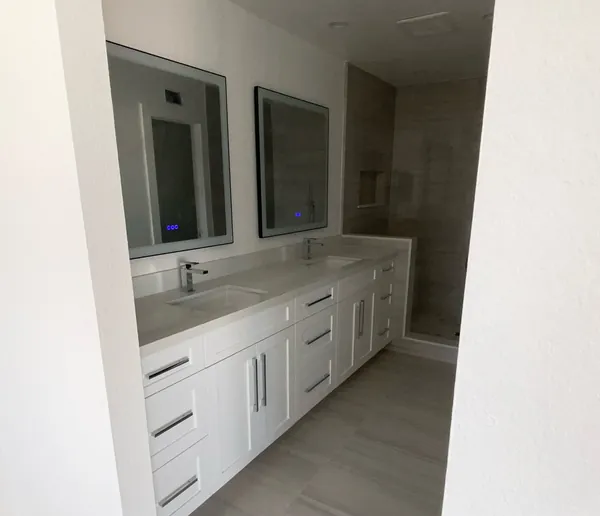 White shaker double vanity with long pulls and backlit mirrors, Simi Valley