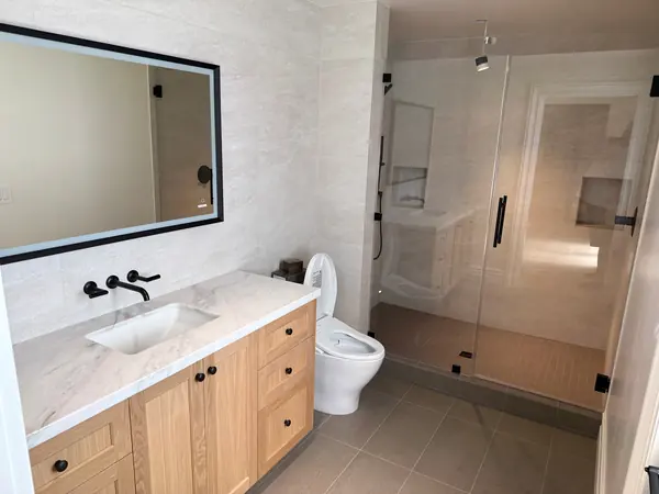 Oak shaker vanity with a wall-mounted faucet beside a glass shower, Thousand Oaks