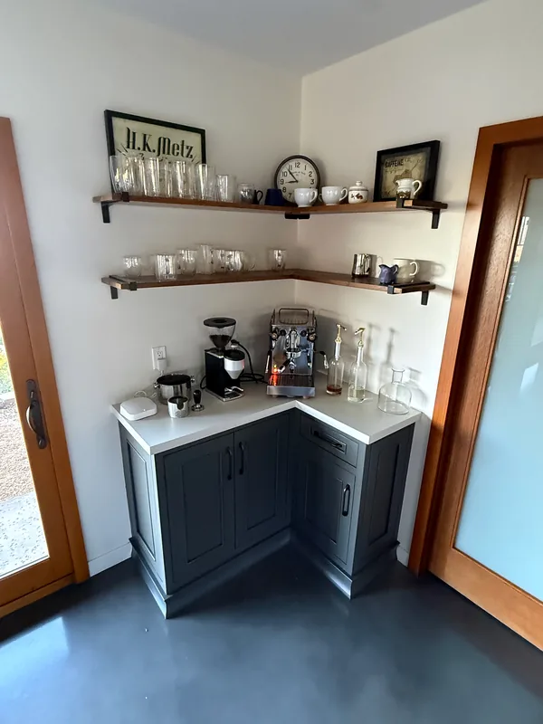 Navy corner bar cabinet with a white top and walnut floating shelves on black brackets, Westlake Village